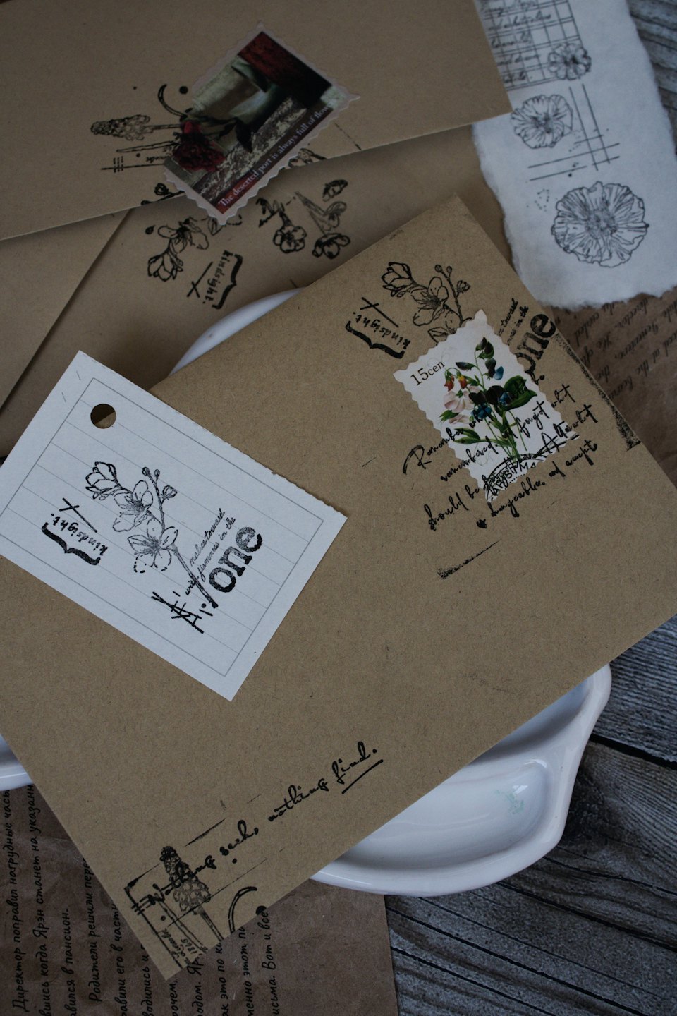 Vintage stationery and floral tags rest on a wooden surface.